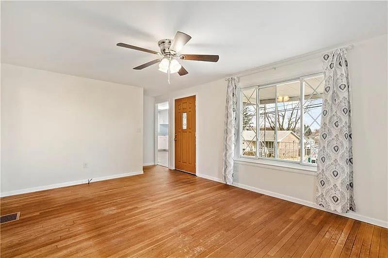 609 Virginia Avenue Rochester, PA 15074 - Photo 3 of 22 a view of an empty room with wooden floor and a window
