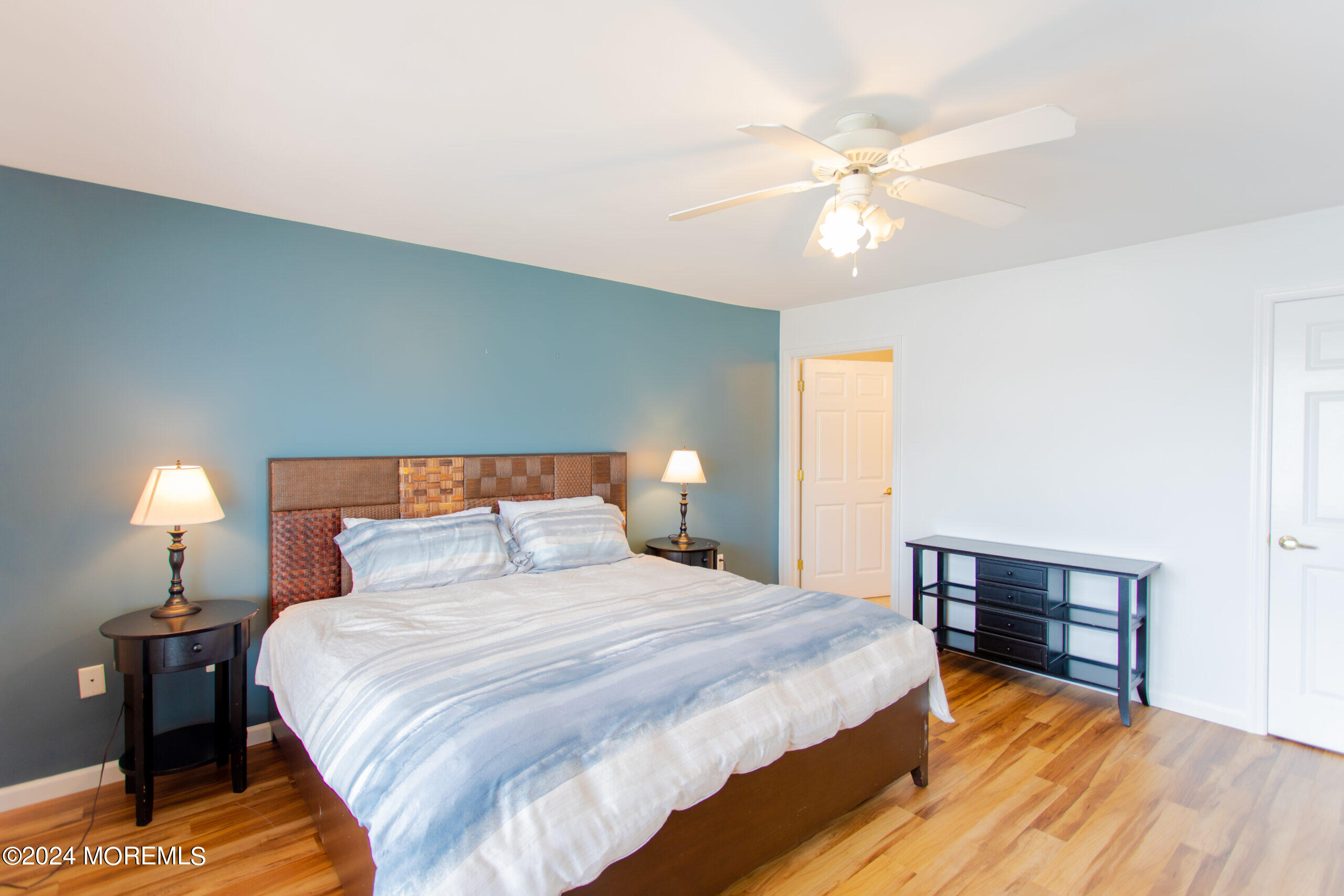 580 East Main Street, Unit 3 Manasquan, NJ 08736 - Photo 24 of 41 a bedroom with a bed and a chandelier