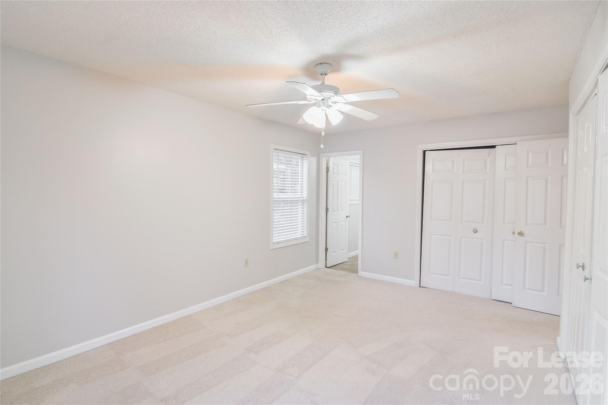 110 Pratt Street Belmont, NC 28012 - Photo 4 of 18 an empty room with chandelier fan and windows
