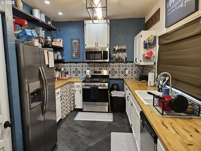 a kitchen with stainless steel appliances a stove and a microwave