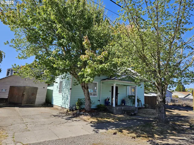a front view of a house with a tree