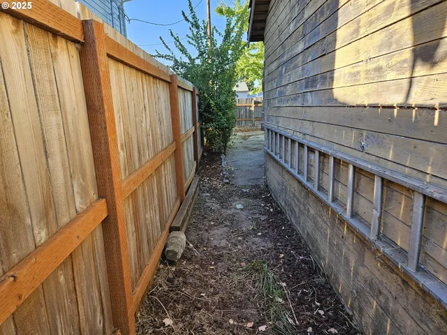 a view of a house with backyard and wooden fence