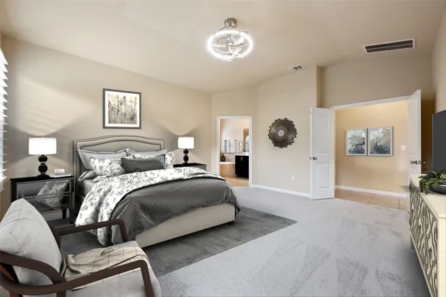 a bedroom with a large bed and a chandelier