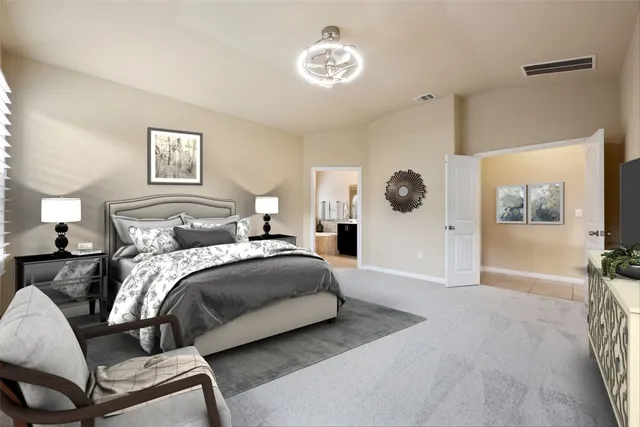 a bedroom with a large bed and a chandelier