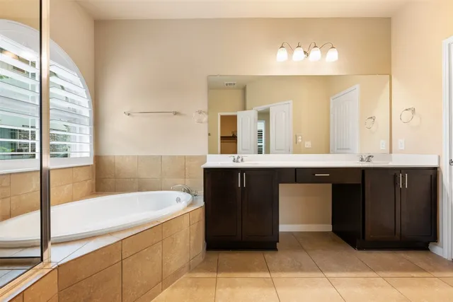 a bathroom with a bathtub sink and mirror