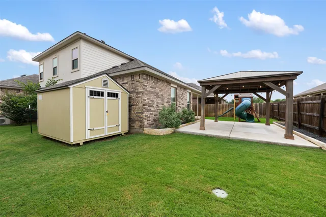 a view of a house with a yard patio and a slide
