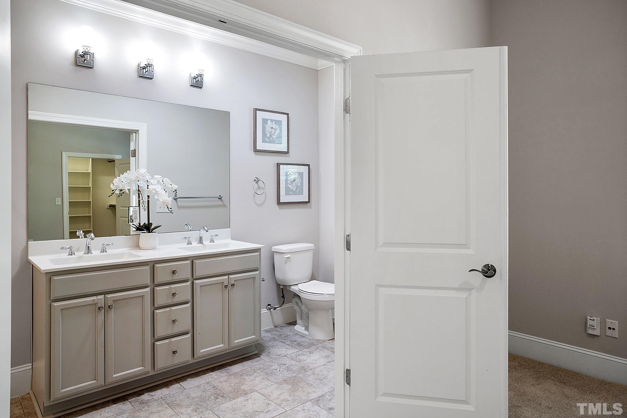 2820 Plumfield Place Raleigh, NC 27607 - Photo 16 of 23 a bathroom with a double vanity sink a toilet and a mirror