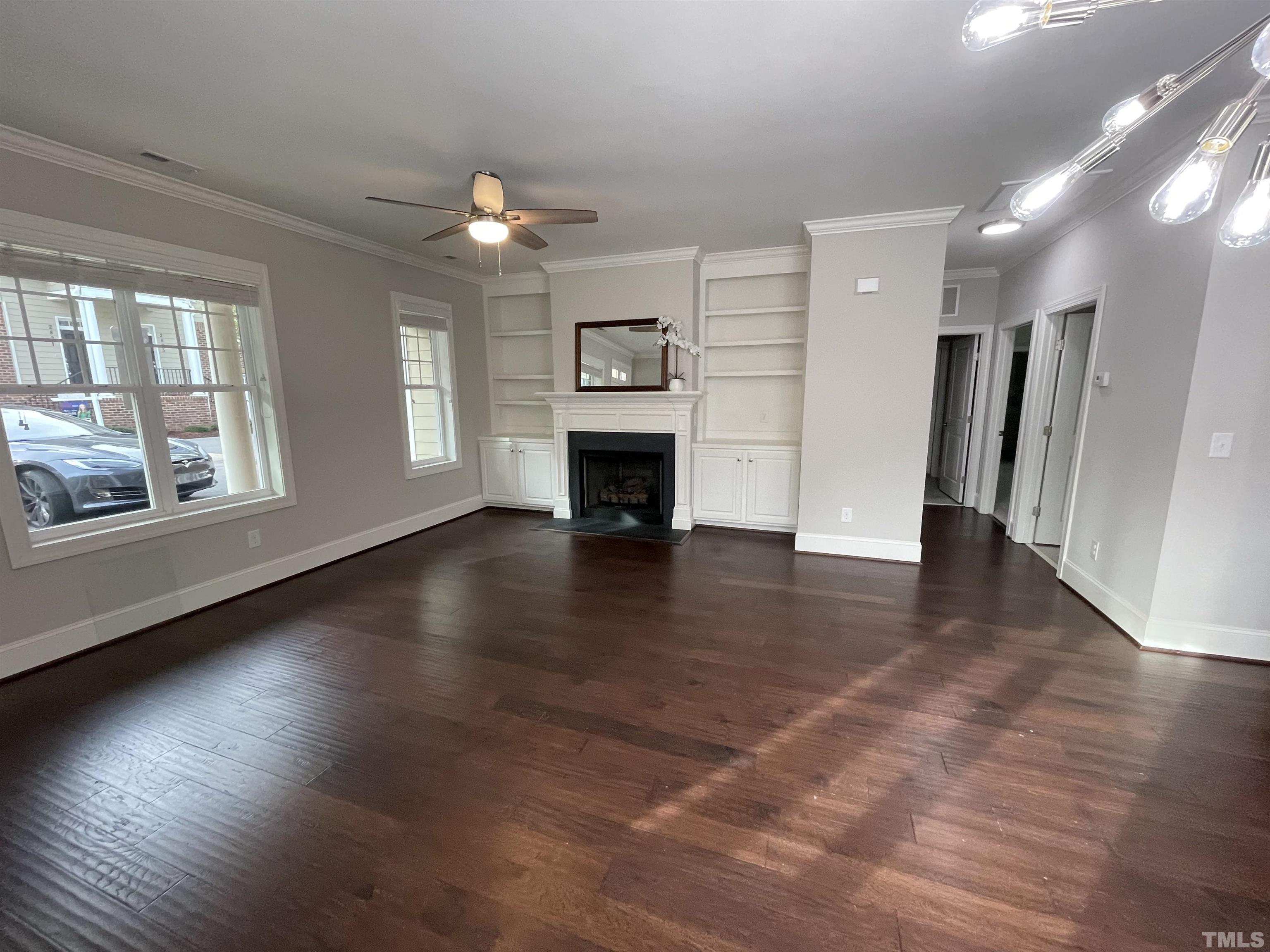 2820 Plumfield Place Raleigh, NC 27607 - Photo 5 of 23 an empty room with wooden floor fireplace and windows