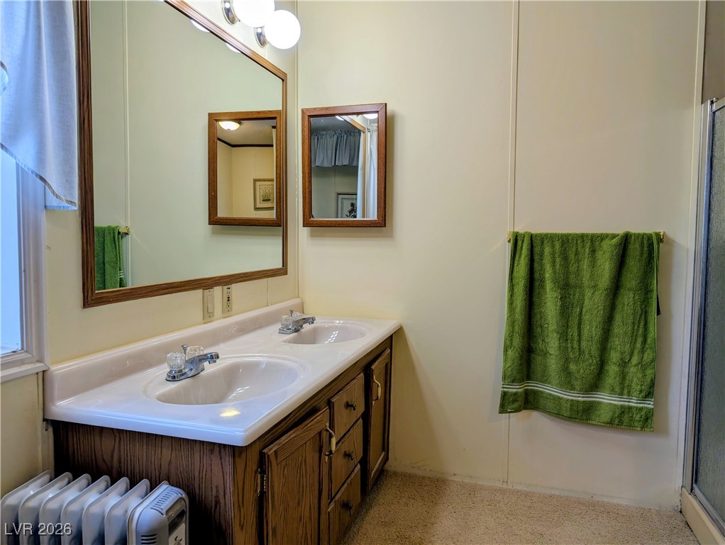 50 North 2nd Street Panaca, NV 89042 - Photo 20 of 35 Bathroom featuring double vanity, radiator heating unit, and a shower with door