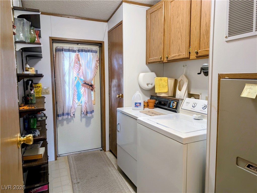 50 North 2nd Street Panaca, NV 89042 - Photo 24 of 35 Laundry room featuring light floors, separate washer and dryer, cabinet space, and a textured ceiling