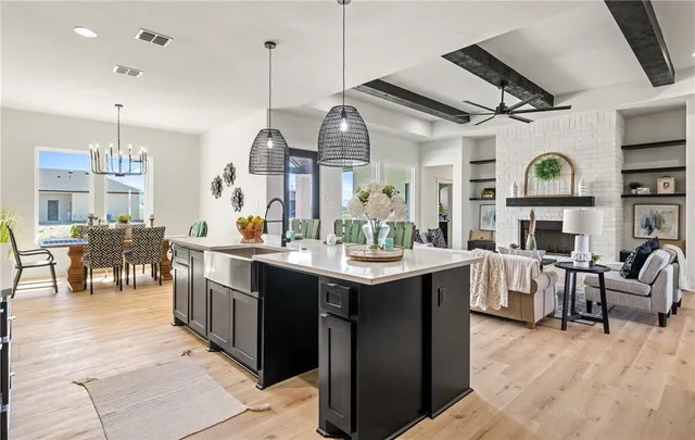 a view of living room kitchen with stainless steel appliances granite countertop furniture and a fireplace
