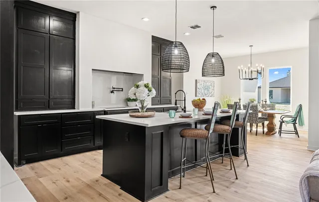 a open kitchen with stainless steel appliances granite countertop a stove refrigerator and chairs
