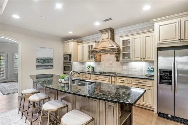 a kitchen with stainless steel appliances granite countertop a sink refrigerator and cabinets