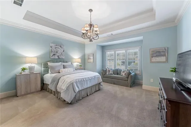 a spacious bedroom with a bed and a chandelier