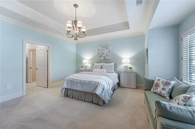 a spacious bedroom with a bed and a chandelier