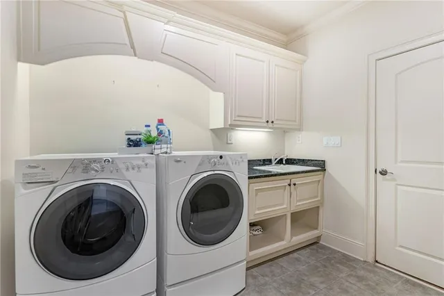 a utility room with cabinets washer and dryer