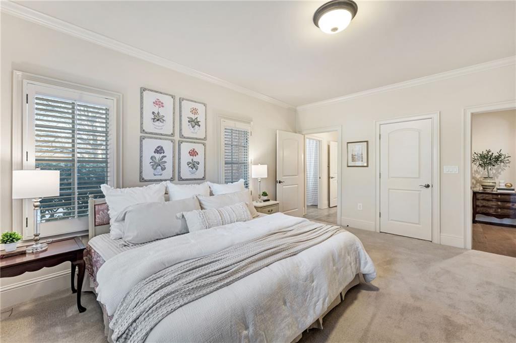 2550 Ballantrae Circle, Unit 53F Cumming, GA 30041 - Photo 27 of 46 a spacious bedroom with a bed and a lamp