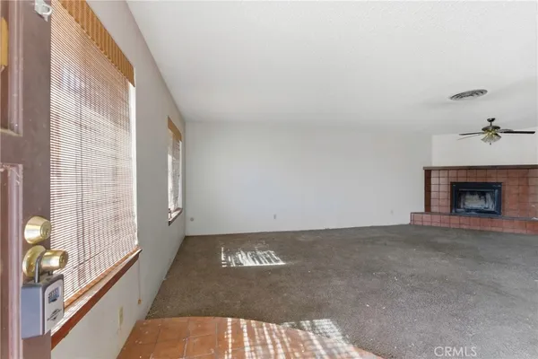 a view of an empty room with a fireplace and a window