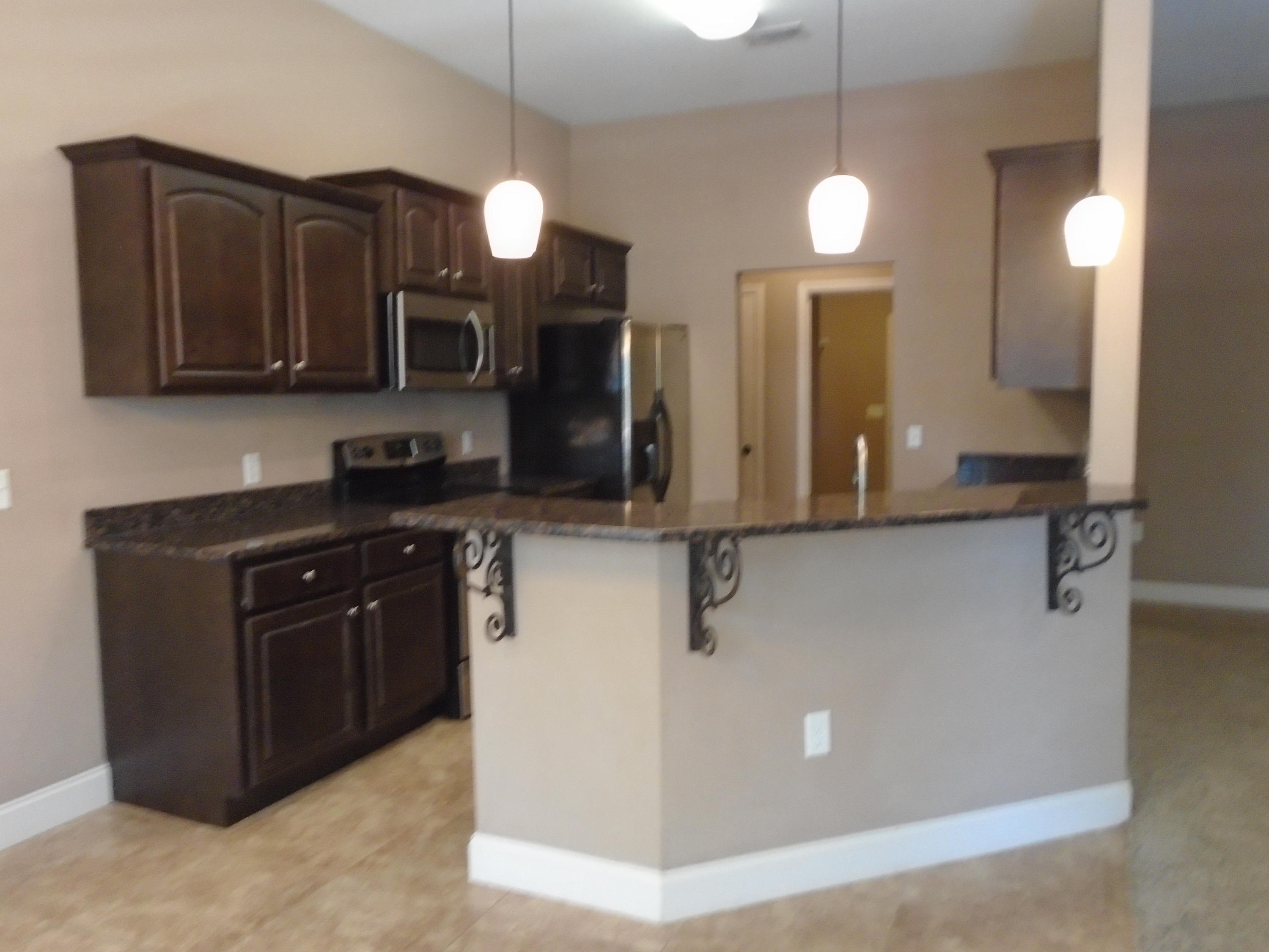 672 Red Fern Road Crestview, FL 32536 - Photo 7 of 27 a kitchen with stainless steel appliances granite countertop a sink a stove and a refrigerator