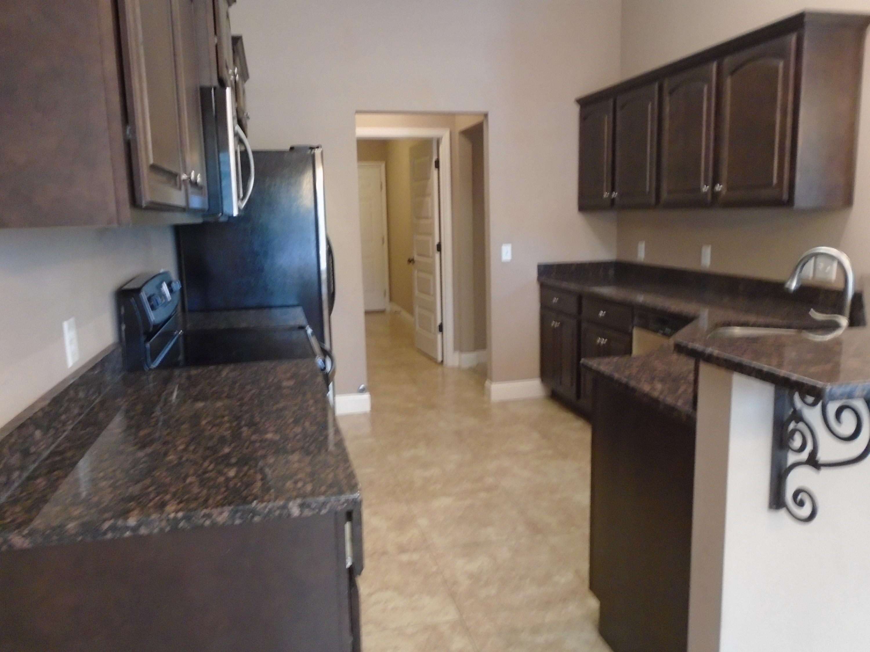 672 Red Fern Road Crestview, FL 32536 - Photo 8 of 27 a kitchen with granite countertop a sink a stove and cabinets