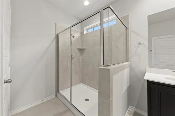 a bathroom with a glass shower door and a sink