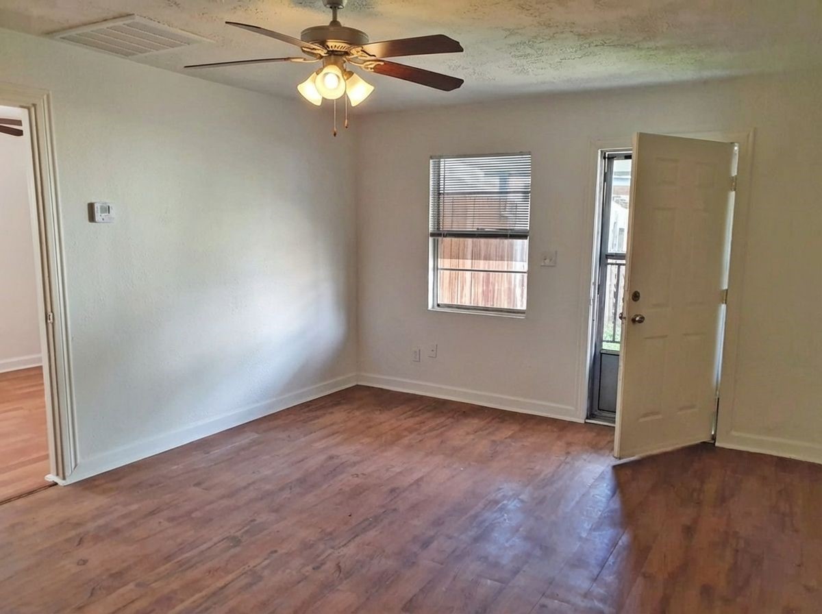 1272 Pecan Street Clute, TX 77531 - Photo 3 of 7 a view of an empty room with a window and wooden floor