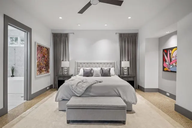 a spacious bedroom with a large bed and a chandelier