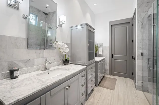a spacious bathroom with a granite countertop double vanity sink mirror and shower