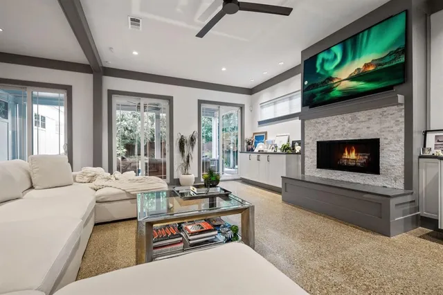 a living room with furniture a flat screen tv and a fireplace
