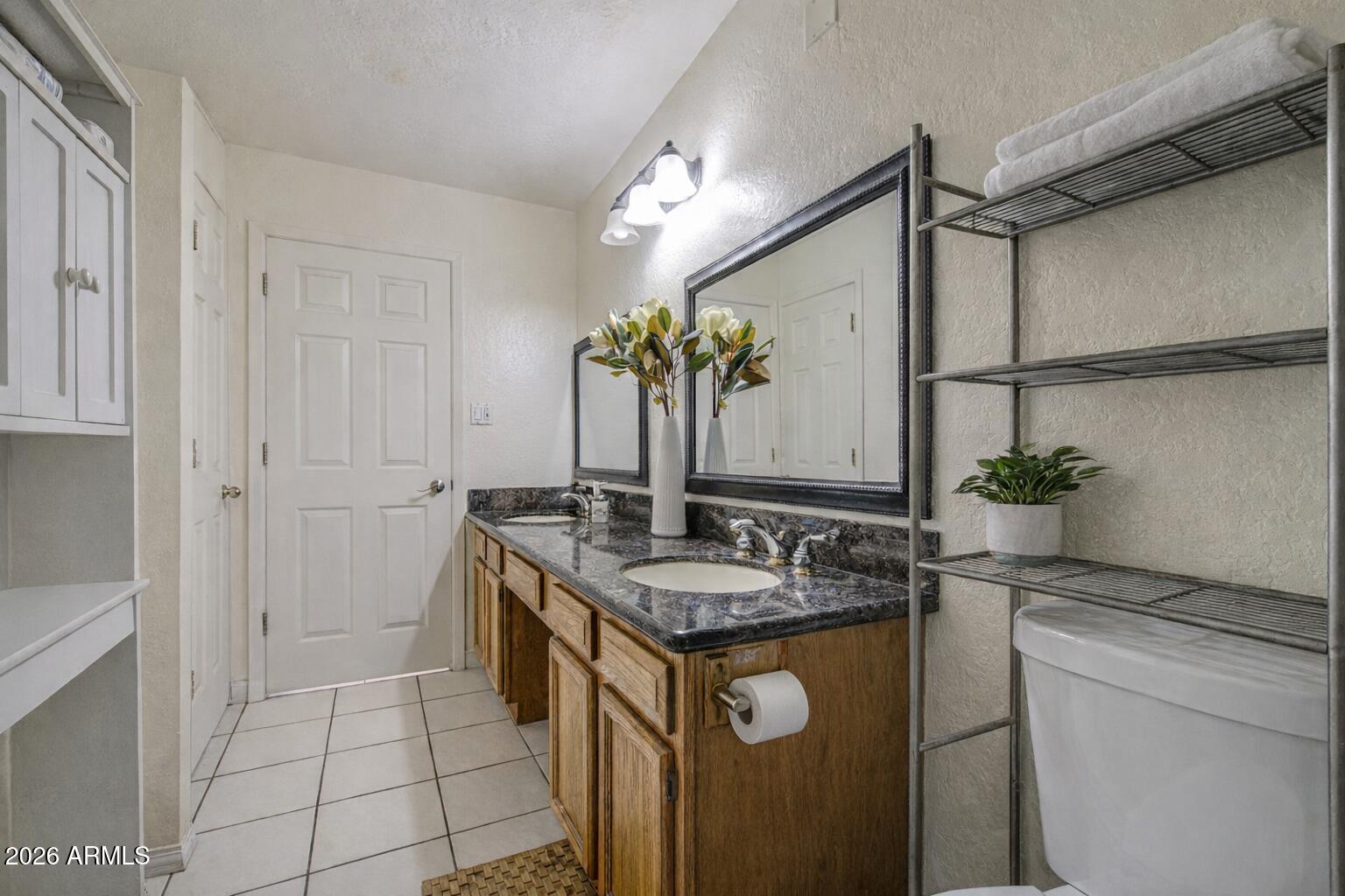 3107 West Montebello Avenue Phoenix, AZ 85017 - Photo 17 of 30 a spacious bathroom with a granite countertop sink a mirror and a shower