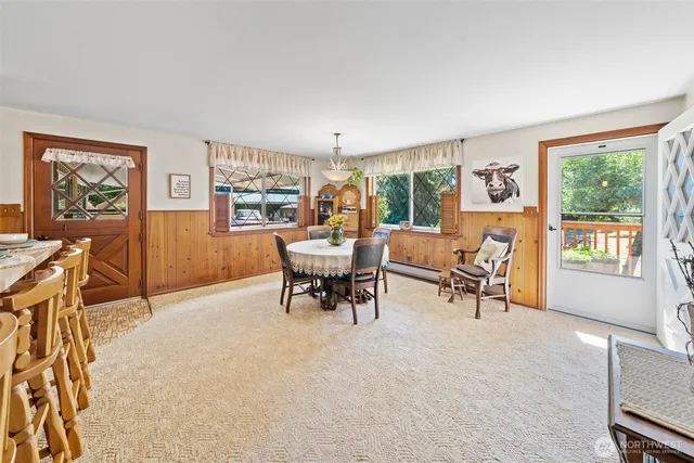 a dining hall with stainless steel appliances kitchen island granite countertop a table and chairs