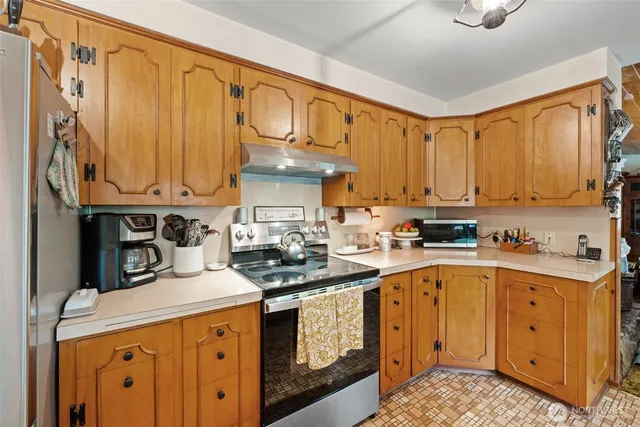 a bedroom with a bed and a dresser next to a window