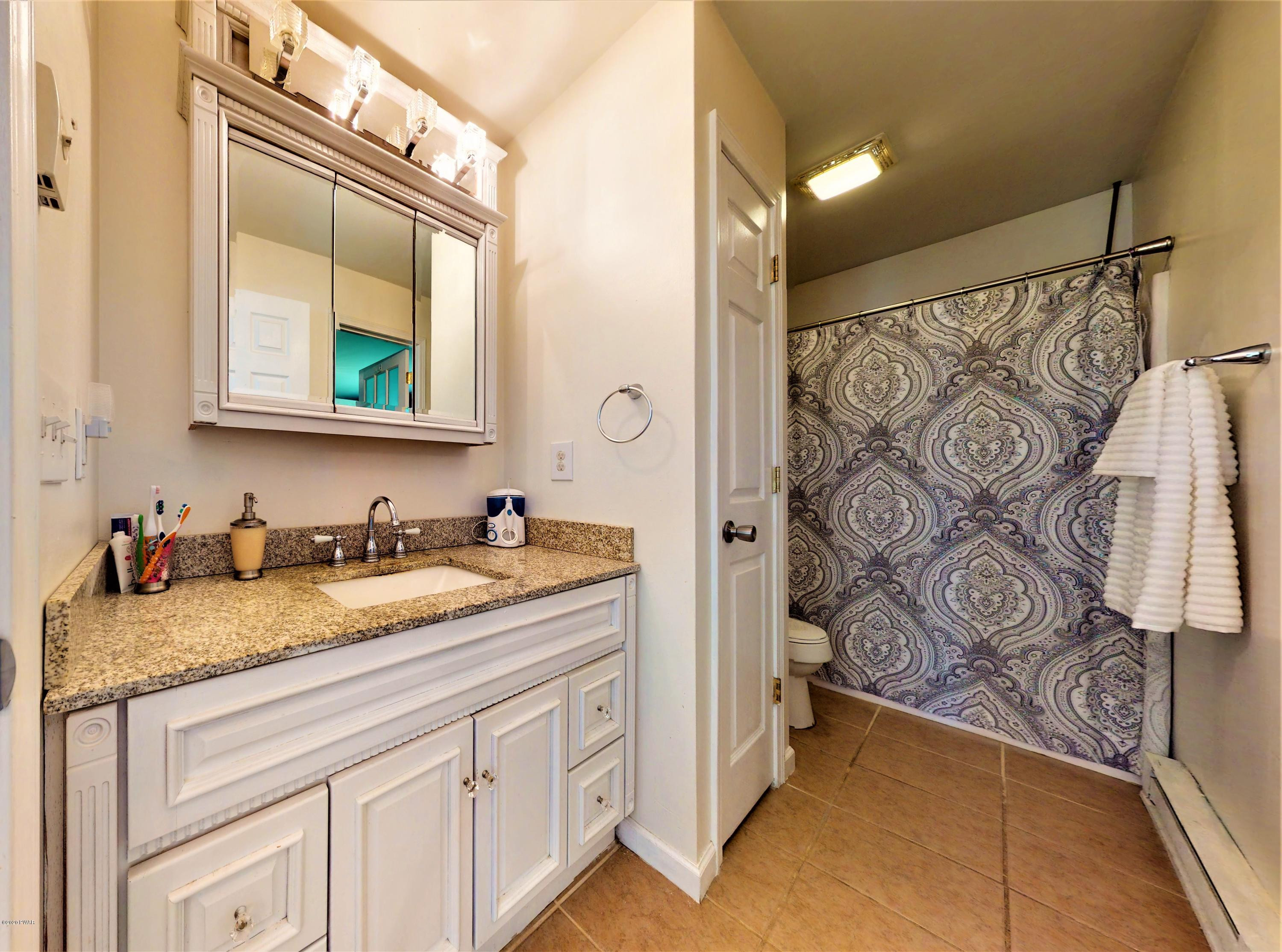 143 Raccoon Road Dingmans Ferry, PA 18328 - Photo 7 of 87 a bathroom with a granite countertop sink and a mirror