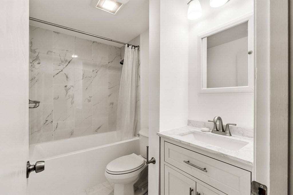 19 Atlantic Road, Unit 12 Gloucester, MA 01930 - Photo 25 of 35 a bathroom with a granite countertop sink a toilet and shower