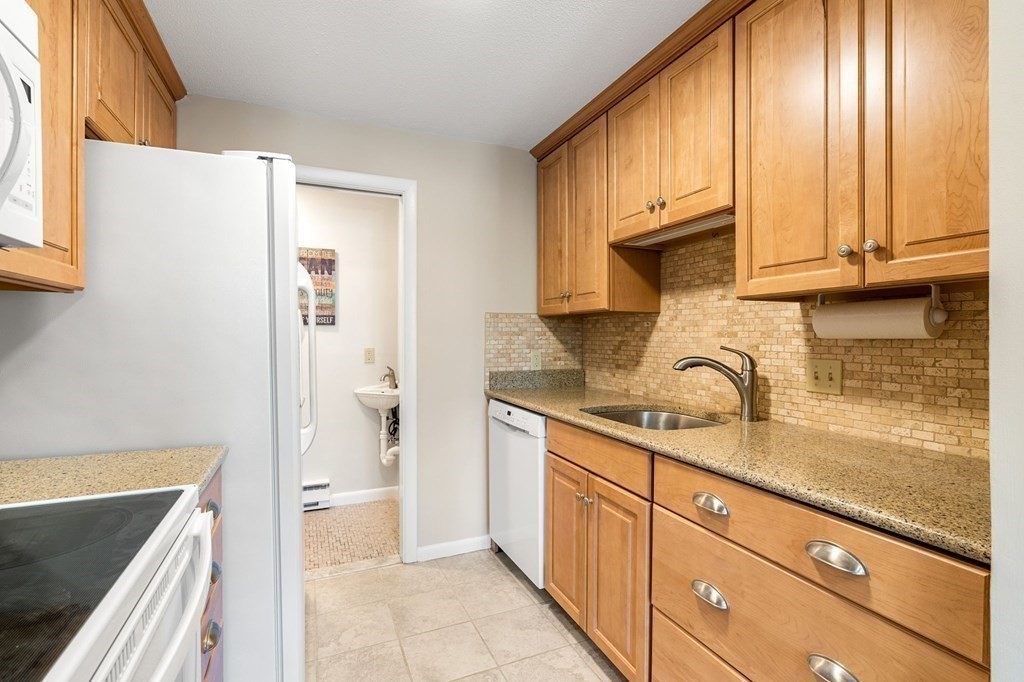 19 Atlantic Road, Unit 12 Gloucester, MA 01930 - Photo 6 of 35 a kitchen with granite countertop a refrigerator sink and cabinets