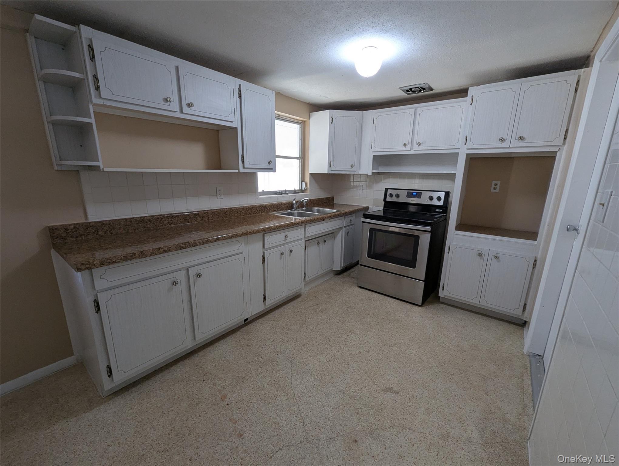 7416 Star Dust Drive Port Richey, FL 34668 - Photo 39 of 44 a kitchen with granite countertop white cabinets and stainless steel appliances