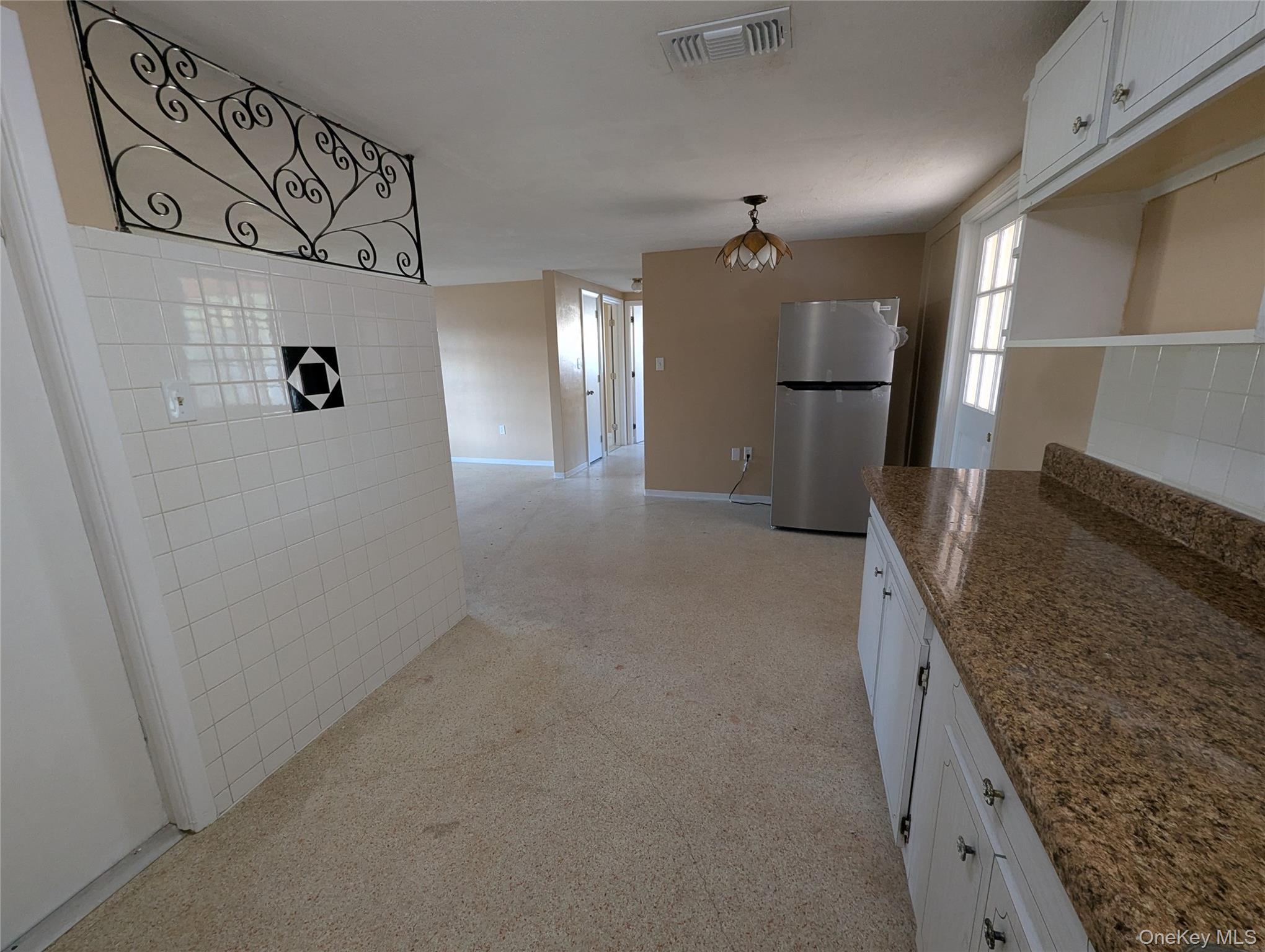 7416 Star Dust Drive Port Richey, FL 34668 - Photo 44 of 44 a view of a refrigerator in kitchen and an empty room