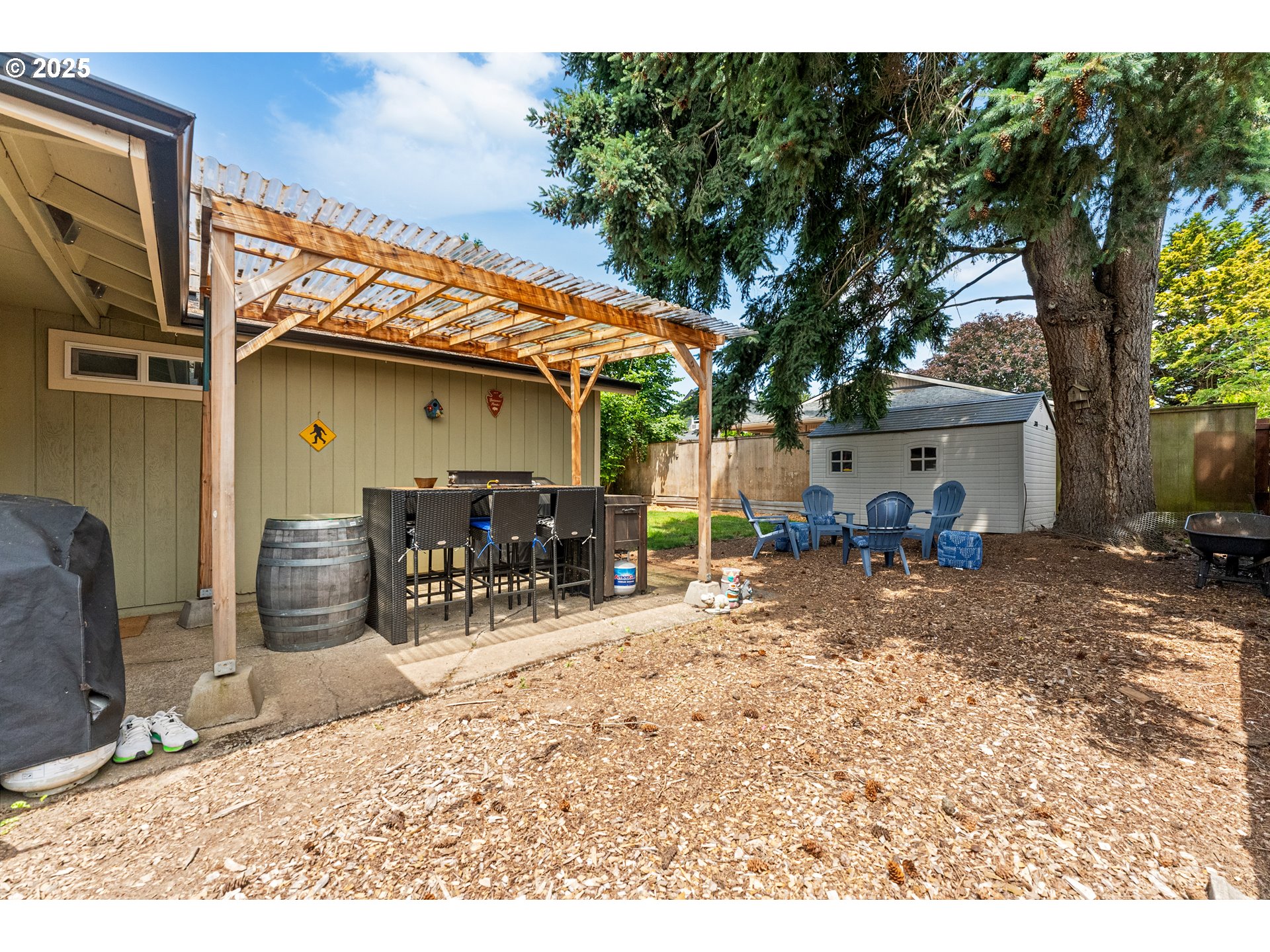 9145 Southeast Oak Street Portland, OR 97216 - Photo 19 of 27 a view of a patio with table and chairs under an large tree