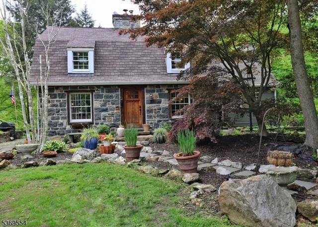 a front view of a house with garden and plants
