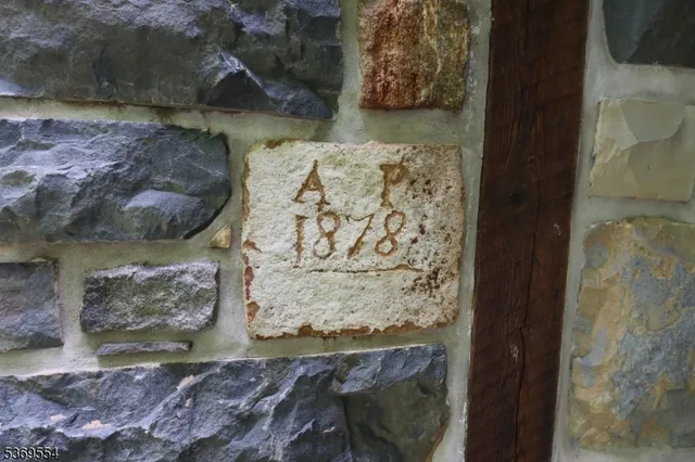 a backyard of a house with table and chairs plants and large trees
