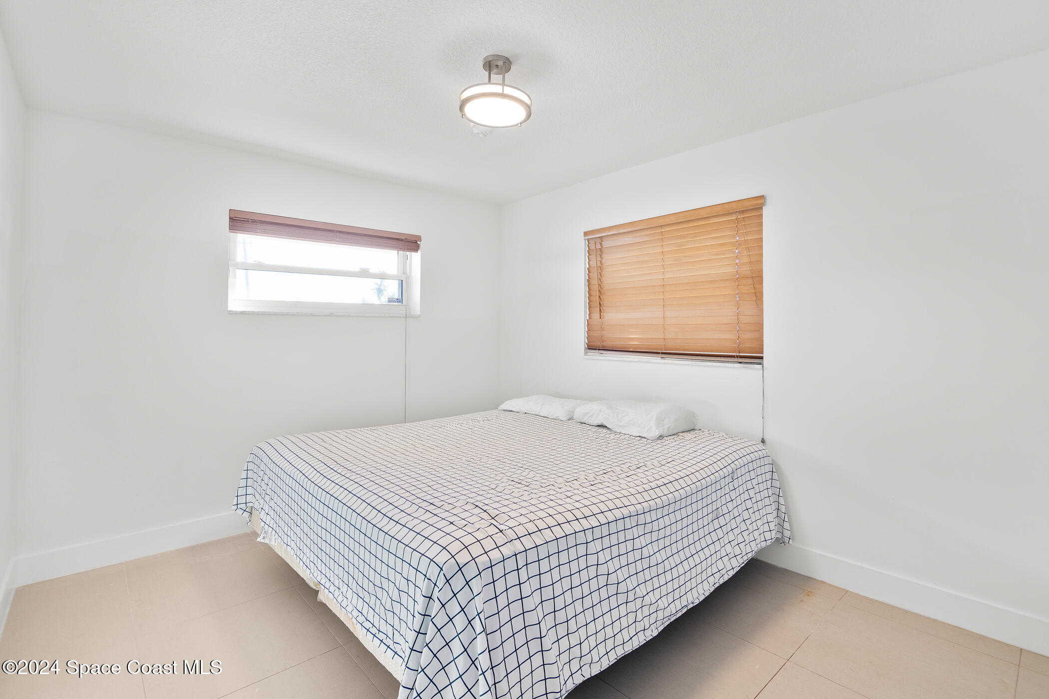 360 East Riviera Boulevard Indialantic, FL 32903 - Photo 14 of 26 a bedroom with a bed and a window