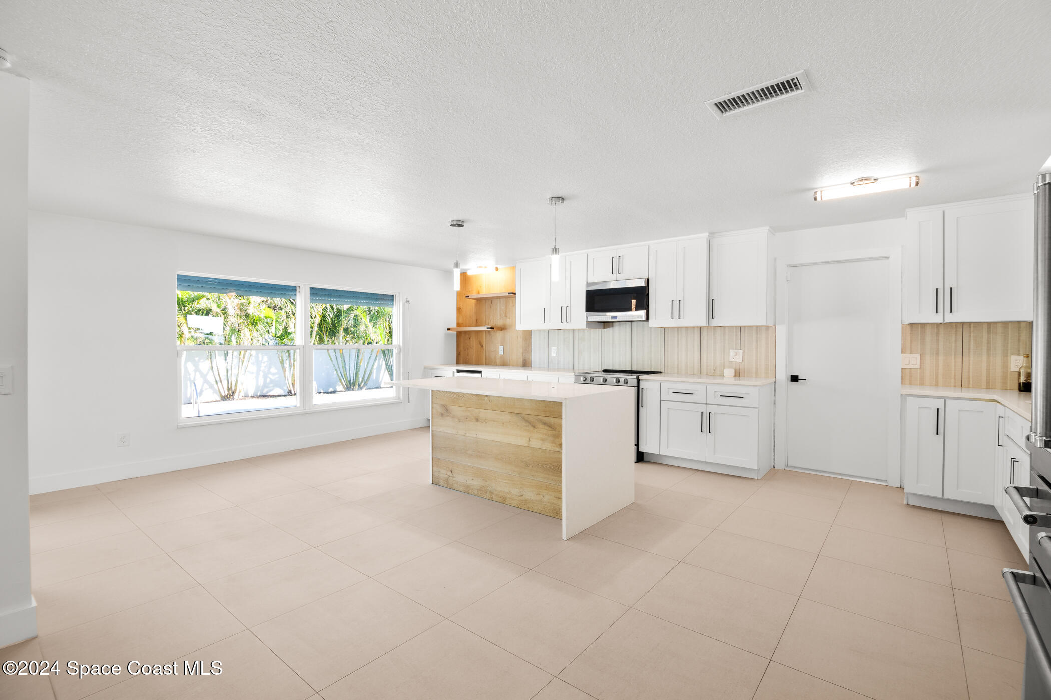 360 East Riviera Boulevard Indialantic, FL 32903 - Photo 3 of 26 a kitchen with white cabinets and white appliances