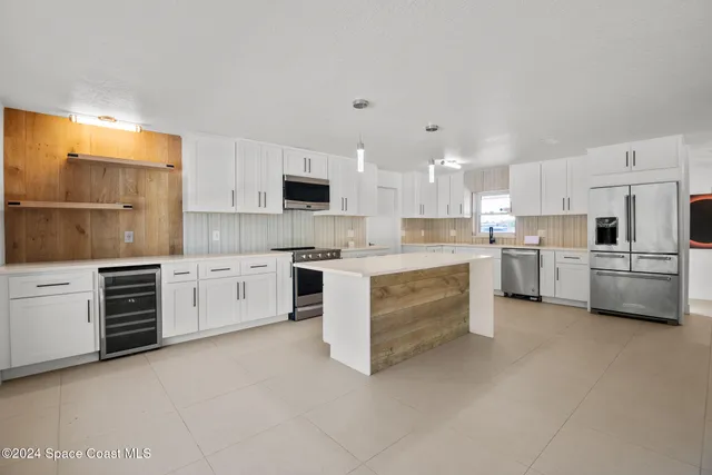 a kitchen with granite countertop white cabinets and stainless steel appliances