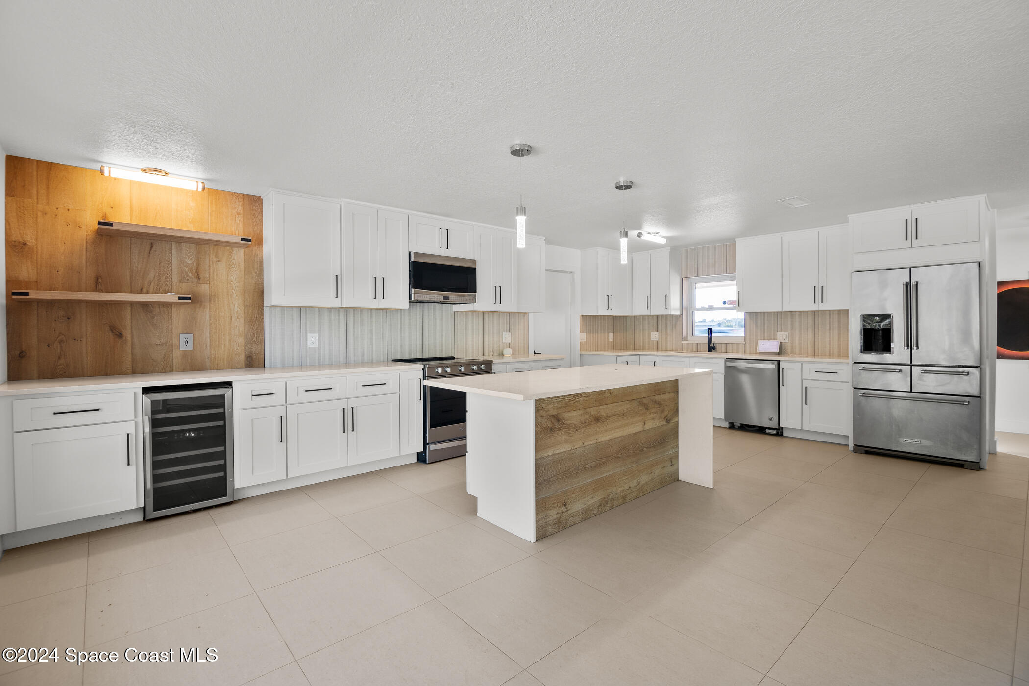 360 East Riviera Boulevard Indialantic, FL 32903 - Photo 5 of 26 a kitchen with stainless steel appliances and white cabinets