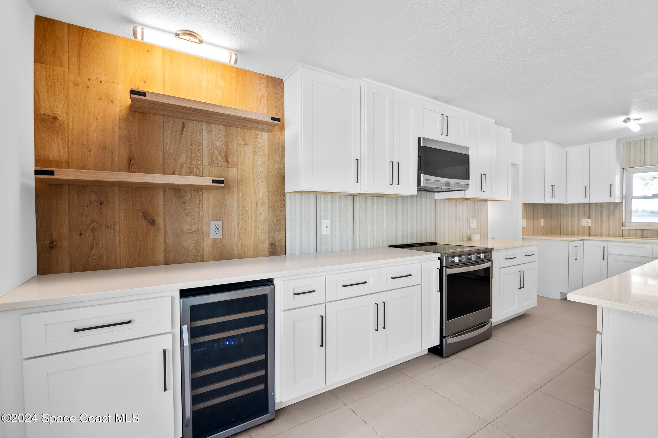 360 East Riviera Boulevard Indialantic, FL 32903 - Photo 6 of 26 a kitchen with granite countertop white cabinets and stainless steel appliances