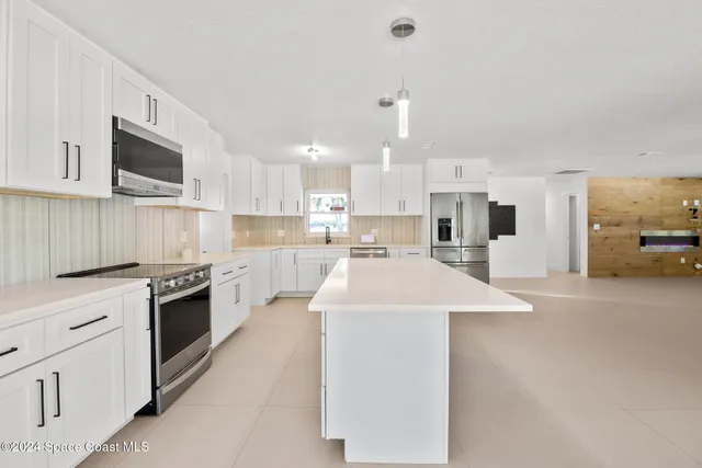 a kitchen with stainless steel appliances a sink stove and cabinets