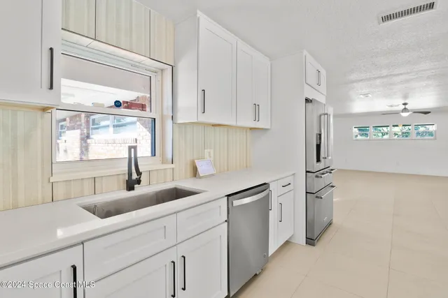 a large kitchen with kitchen island a sink stainless steel appliances and cabinets