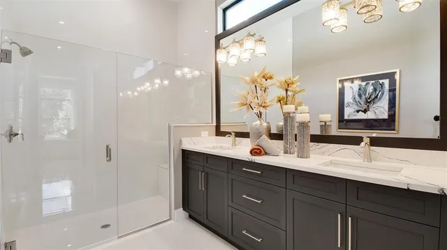 a bathroom with a double vanity sink mirror and shower