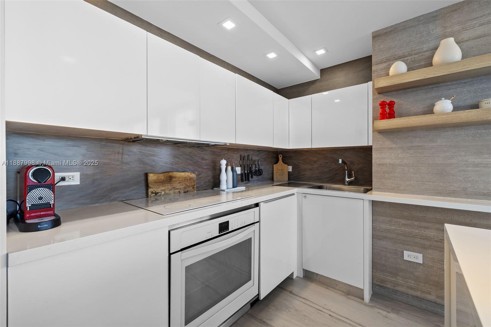 1330 West Avenue, Unit 3407 Miami Beach, FL 33139 - Photo 12 of 42 a kitchen with granite countertop white cabinets and white appliances