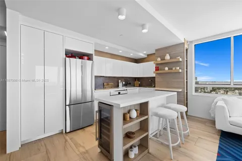 a kitchen with kitchen island wooden cabinets and refrigerator